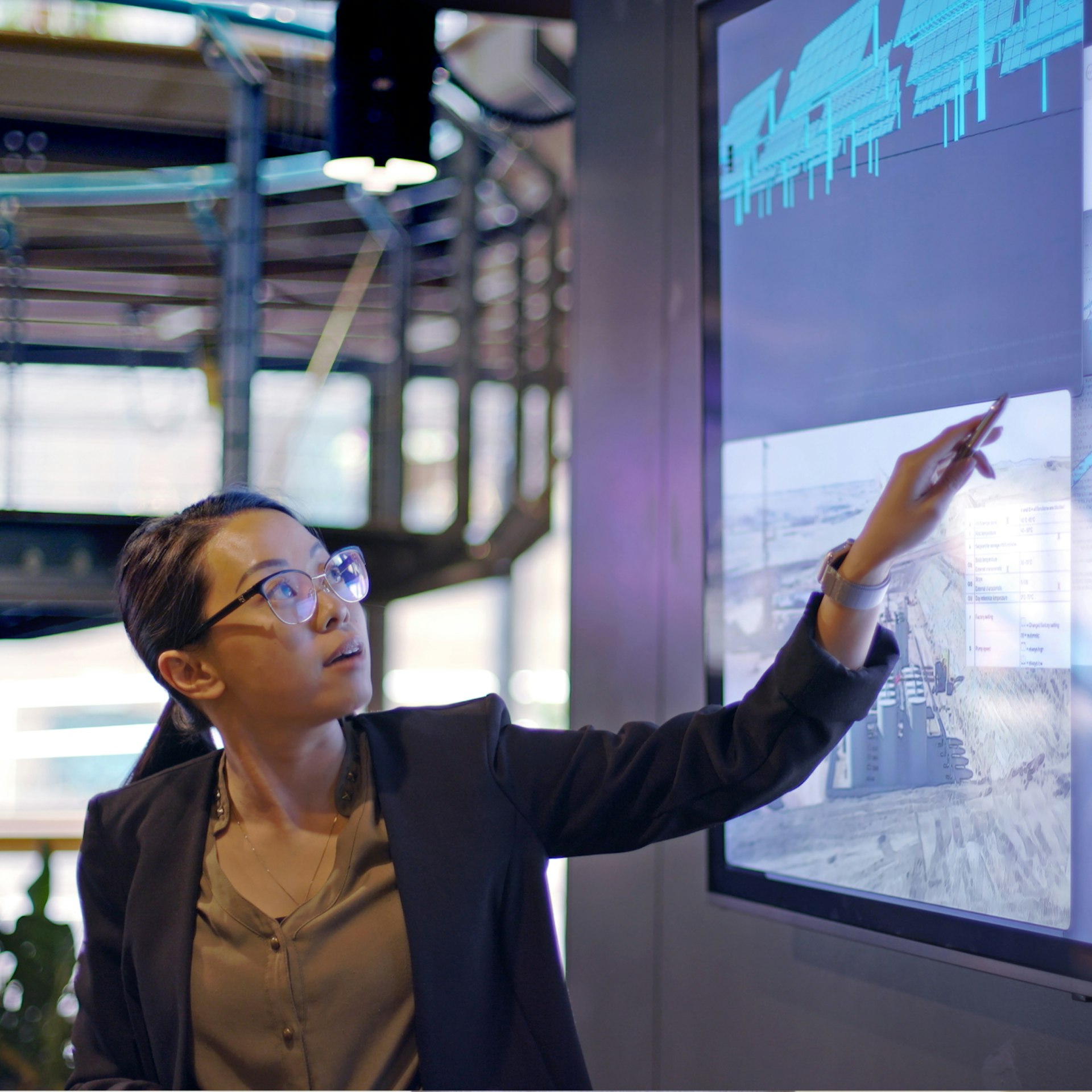 Eine Frau zeigt während einer Präsentation auf einen Bildschirm